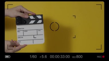 El çırpma tahtası. El ve film çekim tahtası arka plandaki stüdyoda izole edilmiş. Film ya da video yapım konsepti. Alkışlayıcılar kapanıyor. Film ekibi video kaydı için elinde film tahtası tutuyor.