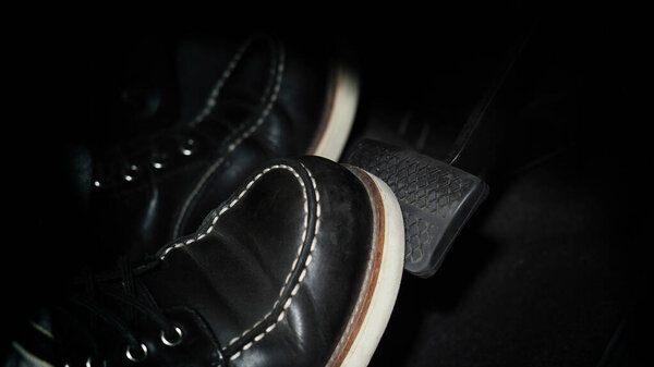 Accelerator and breaking pedal in a car. Close up the foot pressing foot pedal of a car to drive ahead. Driver driving the car by pushing accelerator pedals of the car. Foot pedals inside vehicle.