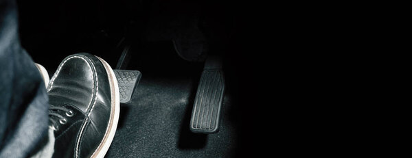 Accelerator and breaking pedal in a car. Close up the foot pressing foot pedal of a car to drive ahead. Driver driving the car by pushing accelerator pedals of the car. Foot pedals inside vehicle.