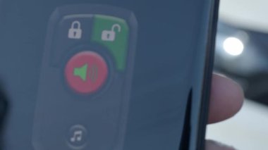 Akıllı Telefon Uygulaması ile Araba 'nın kilidini aç ve kilidini aç. Adam akıllı bir telefondaki mobil uygulamayı kullanarak arabanın kilidini açıyor. İnternet üzerinden uzaktan kumanda ve araba koruması. Akıllı telefonlu araba teknolojisi.