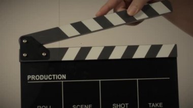 Film tahtası ya da alkış tahtası vuruşu. El ele tutuşup boş film tahtasını tutarak alkışlıyoruz. Video prodüksiyonu için açık ve kapalı film sayfası. Film yapımcılığı. Renkli arka plan stüdyosu Çekime hazır.