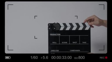 Movie slate or clapperboard hitting. Close up hand holding empty film slate and clapping it. Open and close film slate for video production. film production. color background studio. ready to shoot