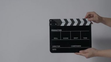 Film tahtası ya da alkış tahtası vuruşu. El ele tutuşup boş film tahtasını tutarak alkışlıyoruz. Video prodüksiyonu için açık ve kapalı film sayfası. Film yapımcılığı. Renkli arka plan stüdyosu Çekime hazır.