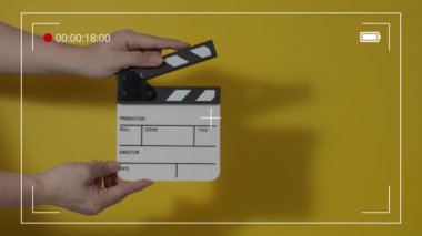 Movie slate or clapperboard hitting. Close up hand holding empty film slate and clapping it. Open and close film slate for video production. film production. color background studio. ready to shoot