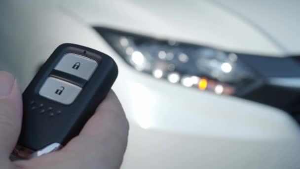 车匙遥控装置用汽车钥匙遥控装置锁住并解锁汽车 当车门打开或关上时 按一下汽车钥匙的按钮 灯就闪了 人手使用自动遥控器键 — 图库视频影像