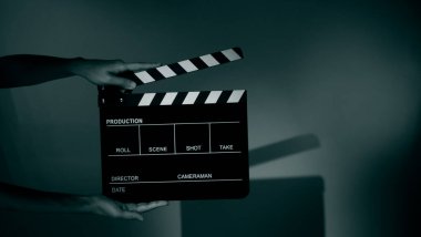 Film tahtası ya da alkışlama tahtasının bulanık görüntüleri. Stüdyoda film çekimi ya da kayıt için renk arkaplanı üzerinde el ele tutuşan boş bir film. Youtuber video üretimi için film tahtası.