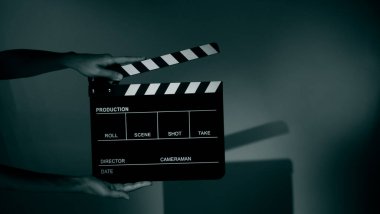Blurry images of movie slate or clapper board. Hand holds empty film making clapperboard on color background in studio for film movie shooting or recording. Film slate for Youtuber video production. clipart