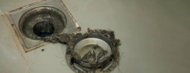 Kanalizasyon temizliği. Tıkanmış ve kirli kanalizasyon boruları boşaltılıyor. Saçları ve birikmiş tıkanmış yağlarla dolu. Banyodaki kanalizasyon sistemini tamir et. Temiz yıkama ve tıkanıklık giderlerini onarmak.