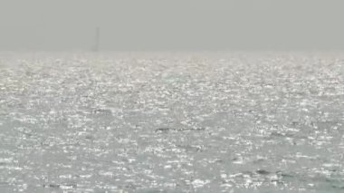 Deniz dalgaları ve mavi gökyüzü. Rüzgârla dalgalanan deniz. Mavi deniz dalgası. Tayland 'ın ünlü deniz mekanlarından biri olan Pattaya plajı. Denizdeki yat limanı limanı. Tatili rahatlatıcı bir şekilde temsil et. Statik Kamera.