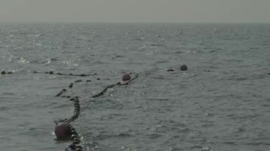 Deniz dalgaları ve mavi gökyüzü. Rüzgârla dalgalanan deniz. Mavi deniz dalgası. Tayland 'ın ünlü deniz mekanlarından biri olan Pattaya plajı. Denizdeki yat limanı limanı. Tatili rahatlatıcı bir şekilde temsil et. Statik Kamera.