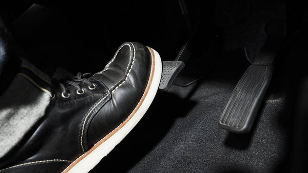 Accelerate and Brake. Foot pressing foot pedal of a car to drive ahead. Accelerator and brake pedal in a car. Driver driving the car by pushing accelerator pedals of the car. inside vehicle automobile