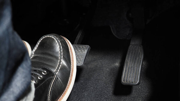 Accelerate and Brake. Foot pressing foot pedal of a car to drive ahead. Accelerator and brake pedal in a car. Driver driving the car by pushing accelerator pedals of the car. inside vehicle automobile