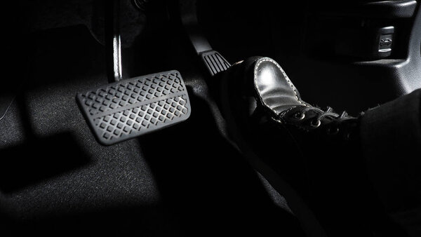 Accelerate and Brake. Foot pressing foot pedal of a car to drive ahead. Accelerator and brake pedal in a car. Driver driving the car by pushing accelerator pedals of the car. inside vehicle automobile