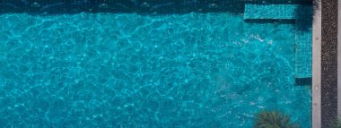 Yaz manzaralı havuz mavisi su. Güneşli bir günde yüzme havuzunun hava görüntüsü spor için uygun ya da tatil zamanı dinlenme ya da tatilde biraz kalori yakma egzersizi için.