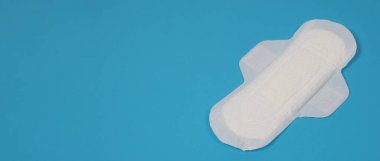 Mavi arka planda kadın hijyenik peçeteleri. Üst Manzara. Adet kanlarını emmek için kadınlar tarafından takılan emme pedleri. Açık mavi kağıda düzenlenmiş konforlu beyaz hijyenik peçeteler. Hijyen kavramını temsil et