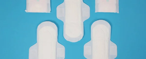 青の背景に女性の衛生ナプキン 最上階だ 月経の血液を吸収するために女性が着用吸収パッド ライトブルーの紙に配置された快適な白い衛生的なナプキン 衛生概念を表す — ストック写真