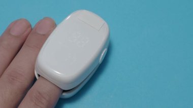 Oksimetre kullanımı. Nabız oksimetresi, nabız ve oksijen seviyelerini ölçmek için kullanılır. Covid 19 salgını sırasında evde bakım. Sağlık hizmeti izleme konsepti. Taşınabilir parmak ucu nabız oksimetresi kullanıyor. 4k