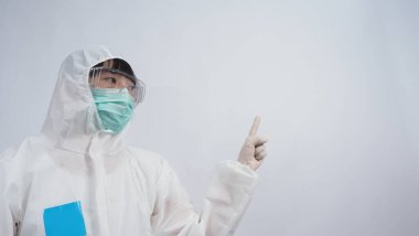 PPE takımındaki doktor beyaz lastik eldivenler ve temiz gözlükler takıyor ve yeşil N95 yüz maskesi salgın Coronavirus 'u koruyor. El işareti yap. Virüsü yenen zaferi temsil ediyor. İzole edilmiş.