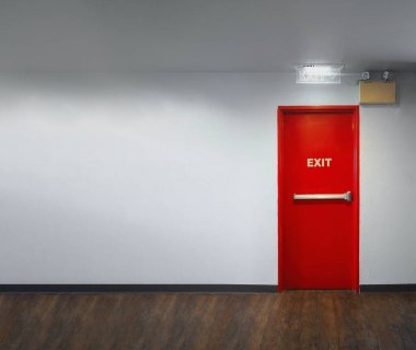 Yangın çıkışı kapısı. Yangın çıkışı kırmızı renkli metal malzeme alarm, acil durum ışığı ve yangın söndürme ekipmanlarıyla güvenlik önlemi için bina duvarına. Kaçış Yangını Kapıları.