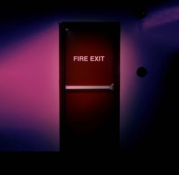 Fire exit door. Fire exit emergency door red color metal material with alarm and emergency light and fire extinguish equipment on building wall for safety protection. Doors for escape conflagration.