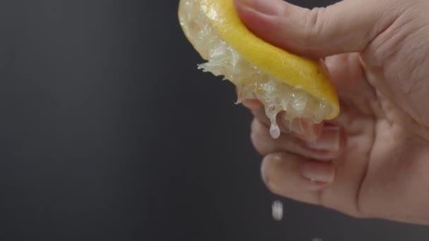 Hand Squeezing Half Lemon Black Background Hand Squeeze Lime Lime — стоковое видео