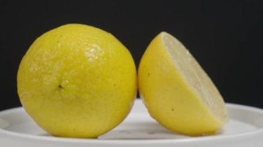 Lezzetli limon pikapta hareket ediyor. Lezzetli limonlar siyah arka planda izole edilir. Tam ve yarım sarı limon koyu arka planda izole edilir. Kapat. Ekşi ve ferahlatıcı içecek menüsünü temsil et.