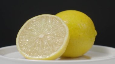 Lezzetli limon pikapta hareket ediyor. Lezzetli limonlar siyah arka planda izole edilir. Tam ve yarım sarı limon koyu arka planda izole edilir. Kapat. Ekşi ve ferahlatıcı içecek menüsünü temsil et.