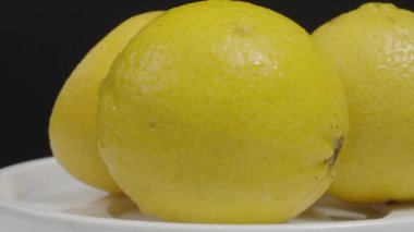 Lezzetli limon pikapta hareket ediyor. Lezzetli limonlar siyah arka planda izole edilir. Tam ve yarım sarı limon koyu arka planda izole edilir. Kapat. Ekşi ve ferahlatıcı içecek menüsünü temsil et.