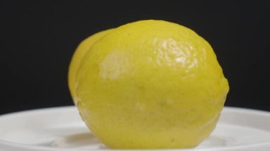 Lezzetli limon pikapta hareket ediyor. Lezzetli limonlar siyah arka planda izole edilir. Tam ve yarım sarı limon koyu arka planda izole edilir. Kapat. Ekşi ve ferahlatıcı içecek menüsünü temsil et.