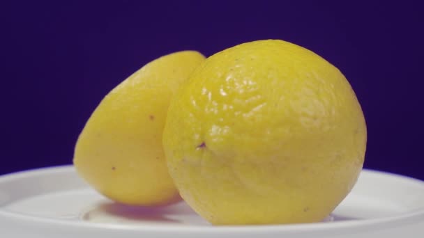 おいしいレモンはターンテーブルに移動します おいしいレモンは黒の背景に隔離されています 全体と半分の黄色のレモンは暗い背景に隔離されています 閉めろ 酸っぱくて爽やかなドリンクメニューを代表する — ストック動画
