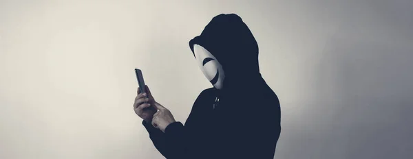 Hacker Anonim Mască Față Smartphone Mână Bărbat Cămașă Neagră Glugă — Fotografie, imagine de stoc