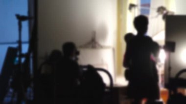 Stüdyoda video yapımcılığında çalışırken görüntüler bulanıklaşır. Video prodüksiyon sahnelerinin arkasında. Yönetmen ve film ekibinin kamera ışıklandırmalı bir filmini çekmek ya da çekmek.