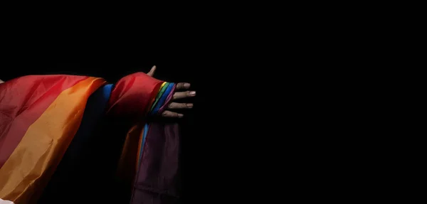 LGBTQ pride flag on black background. Lgbt rainbow flag in gay hand. Represent symbol of freedom peace equality and love and respect  diversity of sexuality. Lesbian Gay Bi sexsual Transgender Queer.