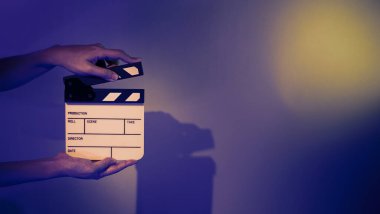 Film alkışlama tahtası. Ekip el kameraya karşı plastik ve ahşap film tahtası tutuyor. Video yapımında ve film stüdyosunda kullanılan alkışlar film endüstrisinde işe yarıyor. Mürettebatın elinde film tahtası.