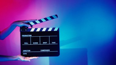 Film alkışlama tahtası. Ekip el kameraya karşı plastik ve ahşap film tahtası tutuyor. Video yapımında ve film stüdyosunda kullanılan alkışlar film endüstrisinde işe yarıyor. Mürettebatın elinde film tahtası.