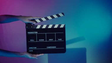 Film alkışlama tahtası. Ekip el kameraya karşı plastik ve ahşap film tahtası tutuyor. Video yapımında ve film stüdyosunda kullanılan alkışlar film endüstrisinde işe yarıyor. Mürettebatın elinde film tahtası.