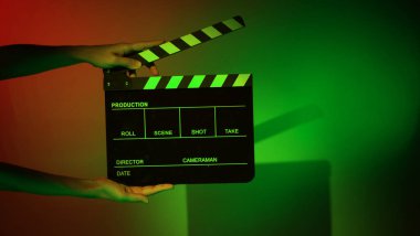 Film alkışlama tahtası. Ekip el kameraya karşı plastik ve ahşap film tahtası tutuyor. Video yapımında ve film stüdyosunda kullanılan alkışlar film endüstrisinde işe yarıyor. Mürettebatın elinde film tahtası.