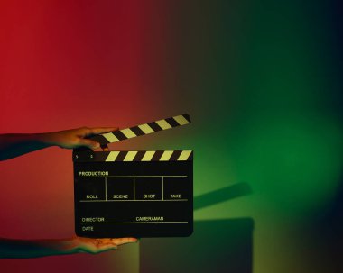 Film alkışlama tahtası. Ekip el kameraya karşı plastik ve ahşap film tahtası tutuyor. Video yapımında ve film stüdyosunda kullanılan alkışlar film endüstrisinde işe yarıyor. Mürettebatın elinde film tahtası.