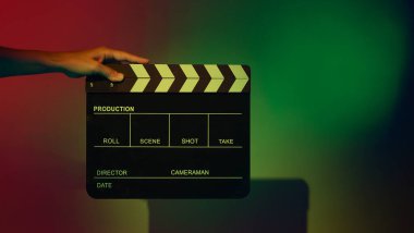 Film alkışlama tahtası. Ekip el kameraya karşı plastik ve ahşap film tahtası tutuyor. Video yapımında ve film stüdyosunda kullanılan alkışlar film endüstrisinde işe yarıyor. Mürettebatın elinde film tahtası.
