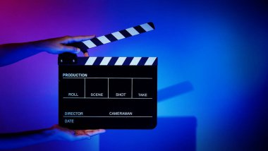 Film alkışlama tahtası. Ekip el kameraya karşı plastik ve ahşap film tahtası tutuyor. Video yapımında ve film stüdyosunda kullanılan alkışlar film endüstrisinde işe yarıyor. Mürettebatın elinde film tahtası.
