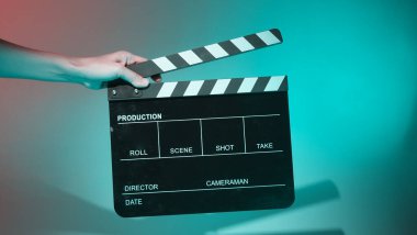 Film alkışlama tahtası. Ekip el kameraya karşı plastik ve ahşap film tahtası tutuyor. Video yapımında ve film stüdyosunda kullanılan alkışlar film endüstrisinde işe yarıyor. Mürettebatın elinde film tahtası.