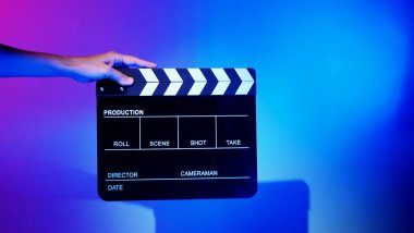 Film alkışlama tahtası. Ekip el kameraya karşı plastik ve ahşap film tahtası tutuyor. Video yapımında ve film stüdyosunda kullanılan alkışlar film endüstrisinde işe yarıyor. Mürettebatın elinde film tahtası.