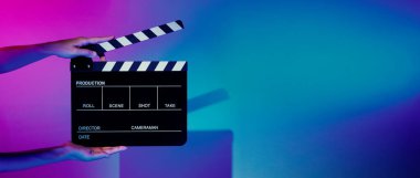 Film alkışlama tahtası. Ekip el kameraya karşı plastik ve ahşap film tahtası tutuyor. Video yapımında ve film stüdyosunda kullanılan alkışlar film endüstrisinde işe yarıyor. Mürettebatın elinde film tahtası.