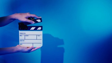 Film alkışlama tahtası. Ekip el kameraya karşı plastik ve ahşap film tahtası tutuyor. Video yapımında ve film stüdyosunda kullanılan alkışlar film endüstrisinde işe yarıyor. Mürettebatın elinde film tahtası.