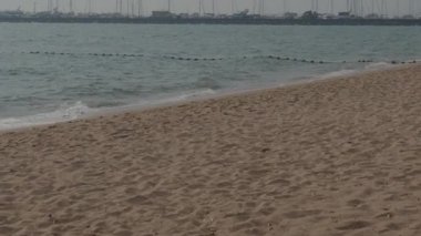 Beach Sand and Sea. Pattaya beach which one of the famous sea locations in Thailand. Represent vacation relaxing. Open country for travelers after Covid 19 pandemic. Sea waves and sand with blue sky.