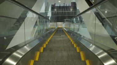 Using Escalator. Point of view or POV Video footage. Close up shot of empty moving staircase running up and down. Modern escalator stairs move indoors going up and down. Escalator with glass sides.