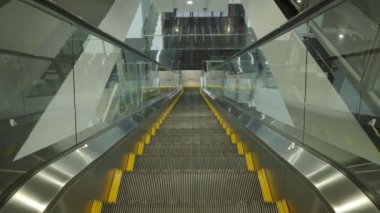 Using Escalator. Point of view or POV Video footage. Close up shot of empty moving staircase running up and down. Modern escalator stairs move indoors going up and down. Escalator with glass sides.