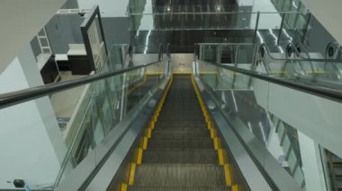 Using Escalator. Point of view or POV Video footage. Close up shot of empty moving staircase running up and down. Modern escalator stairs move indoors going up and down. Escalator with glass sides.