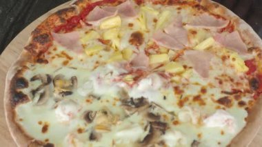 Pizza homemade from brick oven or stone stove. Traditional Italian pizza cooked in heat fired oven. After that cut by circle knife before serving. Fresh Homemade Pizza. Half Seafood and half Hawaiian.