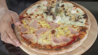 Pizza homemade from brick oven or stone stove. Traditional Italian pizza cooked in heat fired oven. After that cut by circle knife before serving. Fresh Homemade Pizza. Half Seafood and half Hawaiian.
